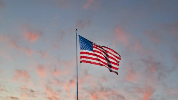 us a flag on pole under cloudy sky